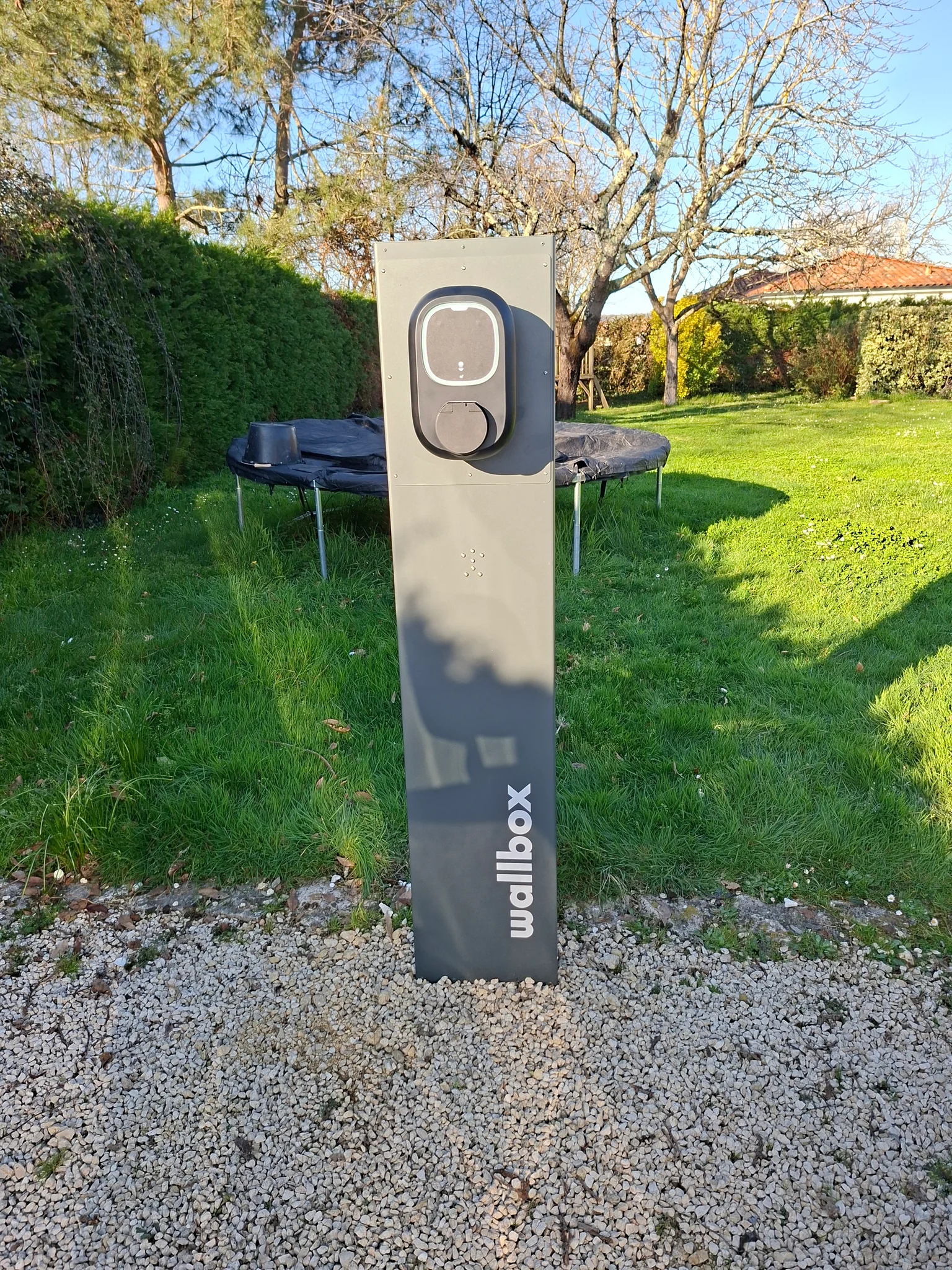 Borne de recharge Wallbox sur pied installée dans le jardin d'un particulier