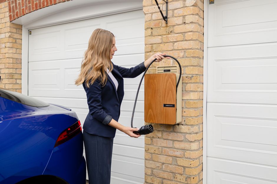 Borne de recharge murale fixée sur un pilier de garage avec son câble