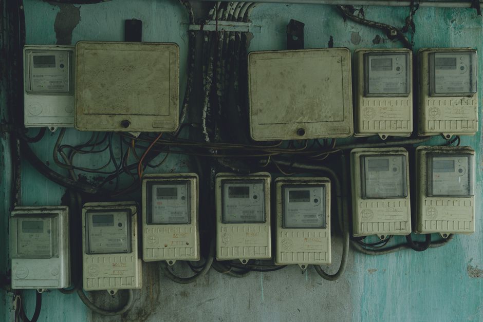 Compteurs et câblages électriques vieillissants sur un mur