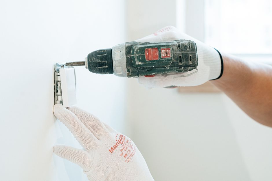 Pose d'une prise électrique murale par un électricien
