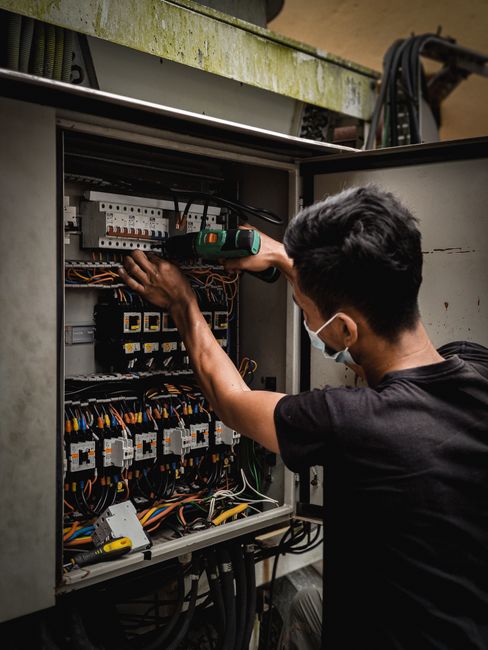 Électricien vérifiant les disjoncteurs d'un tableau électrique